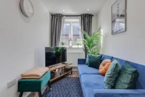 倫敦的住宿－Modern 1 Bed Apartment - Nine Elms, Battersea，客厅配有蓝色的沙发和电视