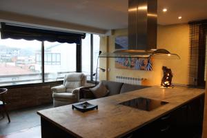 a kitchen with a couch and a table in a room at Apartamentos Zarautz Playa, con piscina y garaje in Zarautz