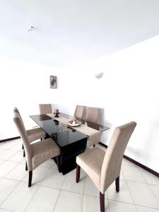 a dining room with a black table and chairs at Bliss Apartments T3 - Zita - On The Beach in Mindelo