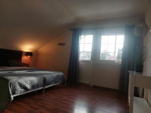 een slaapkamer met een bed en een groot raam bij Øren apartment in Drammen