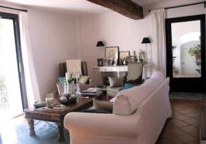 ein Wohnzimmer mit einem weißen Sofa und einem Tisch in der Unterkunft Grande maison en pierre dans la colline varoise in Vidauban