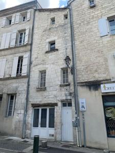 an old brick building with a street light in front of it at La Tour - Hyper Centre - Place du Palet in Angoulême +3 photos