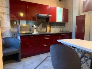 a kitchen with red cabinets and a table and chairs at La Tour - Hyper Centre - Place du Palet in Angoulême
