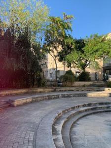 ein leeres Amphitheater in einem Park mit Bäumen und Gebäuden in der Unterkunft La Tour - Hyper Centre - Place du Palet in Angoulême