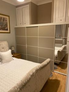 a bedroom with a bed and a book shelf at Cheerful One bedroom cottage with parking space. in Glasgow