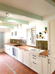 uma cozinha com armários brancos e um lavatório em Provence Verdon em Tavernes