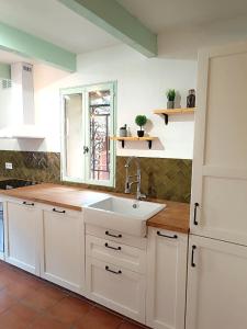 a kitchen with white cabinets and a sink and a window at Provence Verdon in Tavernes