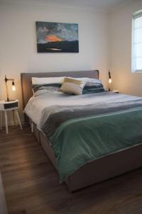 a bedroom with a large bed with two lamps on it at Grif3 Contemporary 2BR Apt w Free Parking in Kingston 