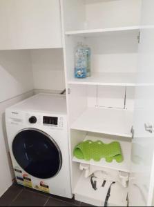 a white washing machine in a kitchen with a green towel at Grif3 Contemporary 2BR Apt w Free Parking in Kingston 