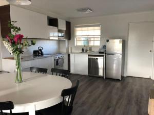 a kitchen with a table with a vase of flowers on it at Grif5 Modern 2BR apartment with Parking in Kingston 