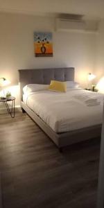 a bedroom with a large white bed with a yellow pillow at Grif5 Modern 2BR apartment with Parking in Kingston 