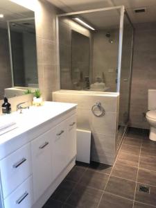 a bathroom with a sink and a shower and a toilet at Grif5 Modern 2BR apartment with Parking in Kingston 