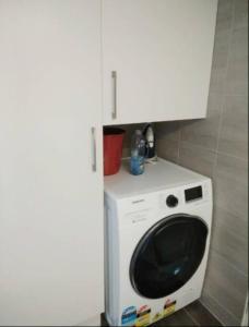a white washer and dryer in a bathroom at Grif5 Modern 2BR apartment with Parking in Kingston 