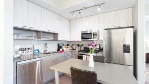 cocina blanca con mesa y nevera en Luxury Apartment In Harbor Point, en Stamford