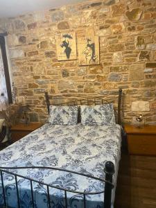 プリノスにあるVilla Aggelikiの石造りの壁のドミトリールーム(ベッド1台)