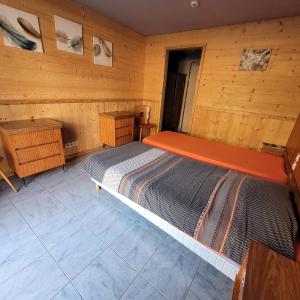 ラ・ブレスにあるHotel du lac des Corbeauxの木製の部屋にベッド1台が備わるベッドルーム1室があります。