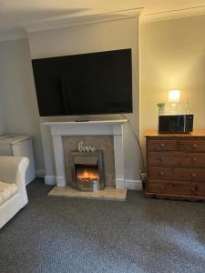 a living room with a fireplace with a flat screen tv at P&S rooms guesthouse Lincoln city centre in Lincolnshire
