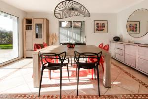 uma sala de jantar com uma mesa de madeira e cadeiras vermelhas em Villa 4 étoiles sur le Golf Makila près de Biarritz em Bassussarry