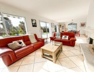 uma sala de estar com dois sofás vermelhos e uma mesa em Villa 4 étoiles sur le Golf Makila près de Biarritz em Bassussarry