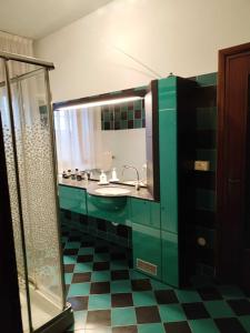 a green bathroom with a sink and a shower at Casa Di Campagna in Gazzo Veronese