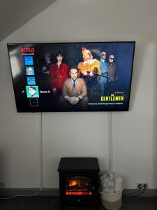 a flat screen tv hanging on a wall next to a fireplace at P&S rooms guesthouse Lincoln city centre in Lincolnshire