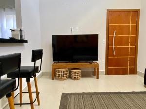 a flat screen tv sitting on top of a wooden table at Casa bem Equipada 3 quartos in Marília