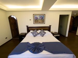 1 dormitorio con 1 cama grande con arcos azules en AVANTI HOTEL & CONVENTION CENTER, en Cochabamba