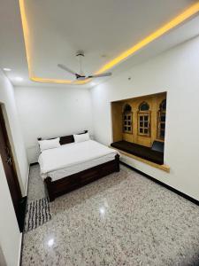 - une chambre blanche avec un lit et une cheminée dans l'établissement Hotel Golden Garh, à Jaisalmer