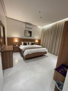 a bedroom with a large bed in a room at شقق الورود بارك in Al Mikhlaf
