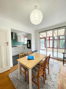 eine Küche und ein Esszimmer mit einem Holztisch und Stühlen in der Unterkunft Greater London House with excellent transport in Forest Hill