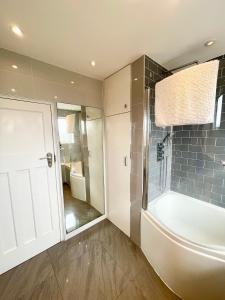 a bathroom with a shower and a bath tub at Greater London House with excellent transport in Forest Hill