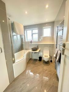 a bathroom with a toilet and a tub and a sink at Greater London House with excellent transport in Forest Hill