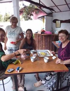 un grupo de personas sentadas alrededor de una mesa de madera en Mereiyans Village Villa en Ampara