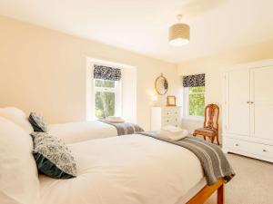 1 dormitorio con 2 camas y 1 silla en 4 Bed in Montrose 89698, en Brechin