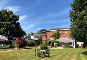 a house with tables and chairs in the yard at The Mill House in Reading