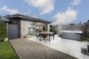 a small backyard with a table and a bath tub at Salt Life, Dunes at Upton Towans in Hayle