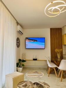 都拉斯的住宿－San Pietro Resort l Gjiri i Lalzit l beachfront，客厅的墙上配有电视
