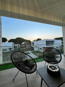 都拉斯的住宿－San Pietro Resort l Gjiri i Lalzit l beachfront，两把椅子坐在带大窗户的庭院