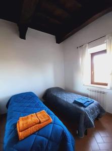 a bedroom with two beds with blue sheets and a window at La Casa di Marco historic center of Capranica (VT) in Capranica