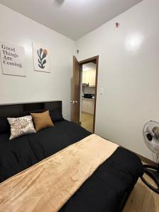 a bedroom with a bed with black sheets and a fan at Matty’s homestay in Manila