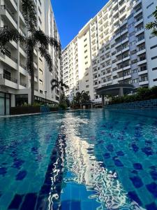 a large swimming pool in front of some buildings at Matty’s homestay in Manila
