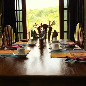 een houten tafel met borden en borden erop bij Manikgoda Tea Paradise in Matugama