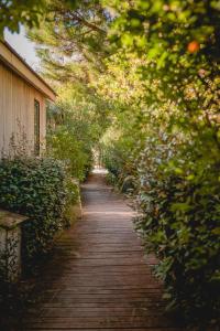 a wooden path with trees and a building at Le Phare in Les Portes