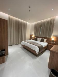 una camera da letto con un grande letto con tende di شقق الورود بارك ad Al Mikhlāf