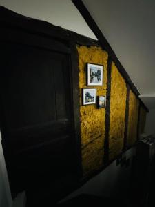 サルラ・ラ・カネダにあるAppartement* authentique meublé Sarlat coeur villeの黄色の壁に二枚の絵を描いた廊下