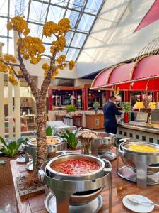 ein Restaurant mit einem Baum in der Mitte eines Tisches in der Unterkunft Castro's Park Hotel in Goiânia