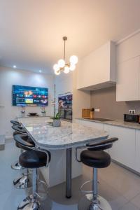 a kitchen with a marble counter top and bar stools at Fish Market Apartments in Brussels