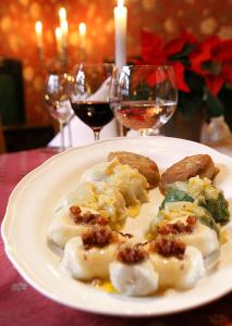 une assiette de nourriture sur une table avec des verres de vin dans l'établissement Hotel Kresowianka, à Bydgoszcz