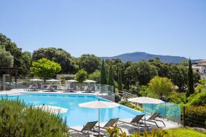 een zwembad met stoelen en parasols bij Eluard 04 - Domaine d'Arca - PORTO-VECCHIO - Rez de jardin - 4 à 6 pers in Porto-Vecchio +5 foto's