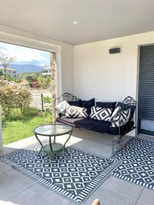 een woonkamer met een bank en een glazen tafel bij Eluard 04 - Domaine d'Arca - PORTO-VECCHIO - Rez de jardin - 4 à 6 pers in Porto-Vecchio
